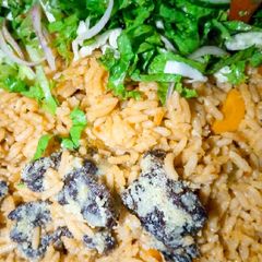 A picture of Native Jollof rice with salad.