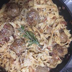 A picture of Pork and beef meatballs in a slow braised tomato sauce and pasta.
