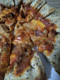 Una foto de Pizza con bordes de queso y masa de semillas