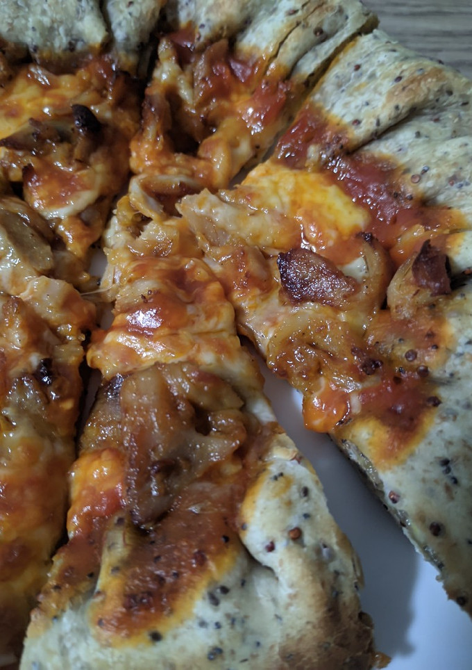 Una foto de Pizza con bordes de queso y masa de semillas