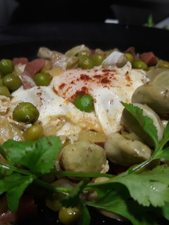 Una foto de Guisantes y habitas con jamón y huevos escalfados
