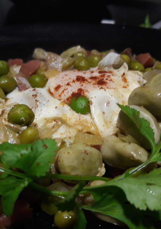 Una foto de Guisantes y habitas con jamón y huevos escalfados