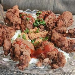 A picture of Crispy fried chicken on creamy lettuce bed.