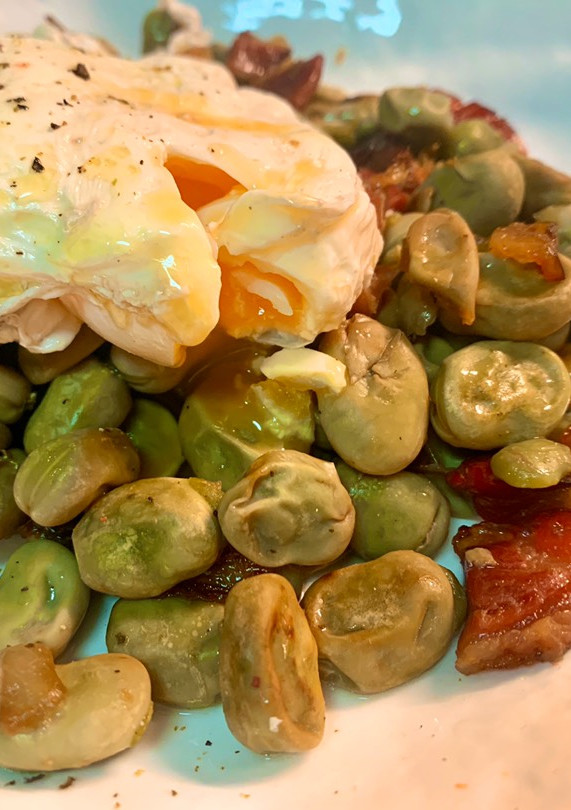 Una foto de Habitas con jamón, cebolla y huevo poché