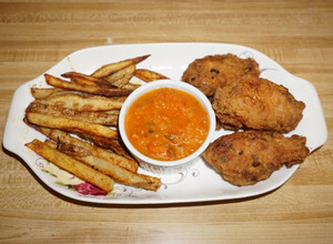 Una foto de ALAS DE POLLO FRITAS, PAPAS ASADAS ALROMERO, SALSA PICANTE