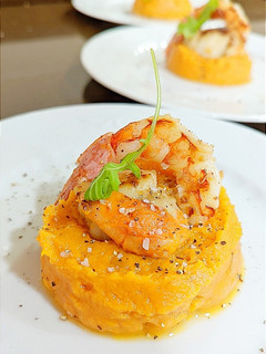 Una foto de Vieiras y gambas sobre puré de boniatos con salsa de whisky