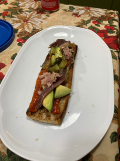 Una foto de Tosta de escalivada, aguacate, atún, anchoas y pepinillo