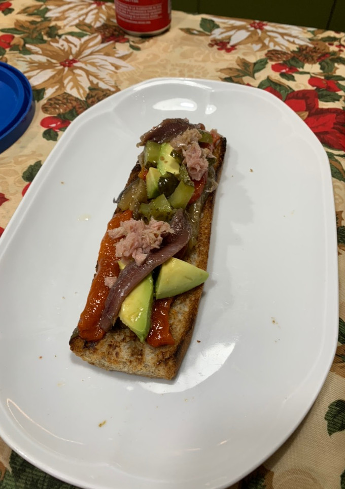 Una foto de Tosta de escalivada, aguacate, atún, anchoas y pepinillo