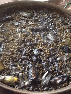 Una foto de Arroz negro de alcachofas, habas y ajos tiernos