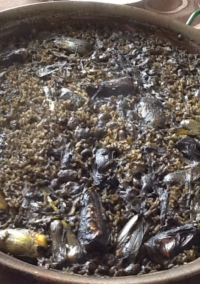 Una foto de Arroz negro de alcachofas, habas y ajos tiernos