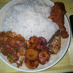 A picture of Sauce stew with white rice and plantain.
