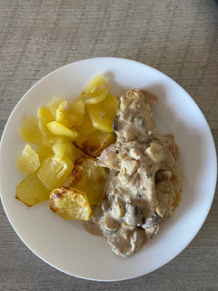 Una foto de Pavo al ajillo con salsa de champiñones y guarnición de patatas al horno