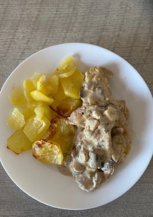 Una foto de Pavo al ajillo con salsa de champiñones y guarnición de patatas al horno