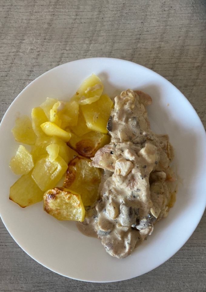 Una foto de Pavo al ajillo con salsa de champiñones y guarnición de patatas al horno