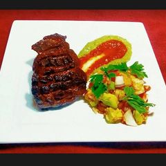 A picture of Steak on Avocado Puree and Mango Slaw.