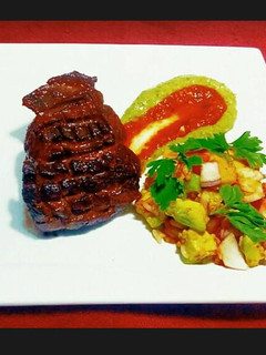 A picture of Steak on Avocado Puree and Mango Slaw.