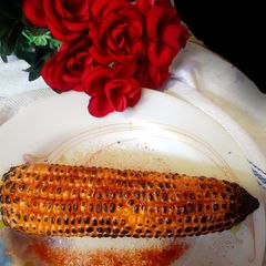 A picture of Garma garam saikha hoa bhutta/ corn on the cob In stove flame.