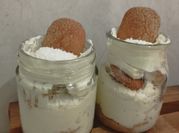 Una foto de postres en vasitos con vainillas