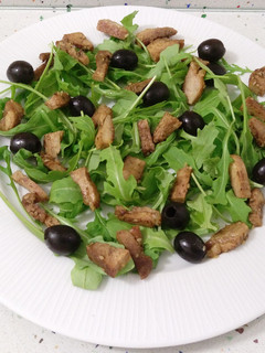 Una foto de Ensalada templada de rúcula con pechuga salteada y aceitunas
