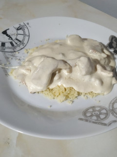 Una foto de Pollo con salsa de queso y cuscús