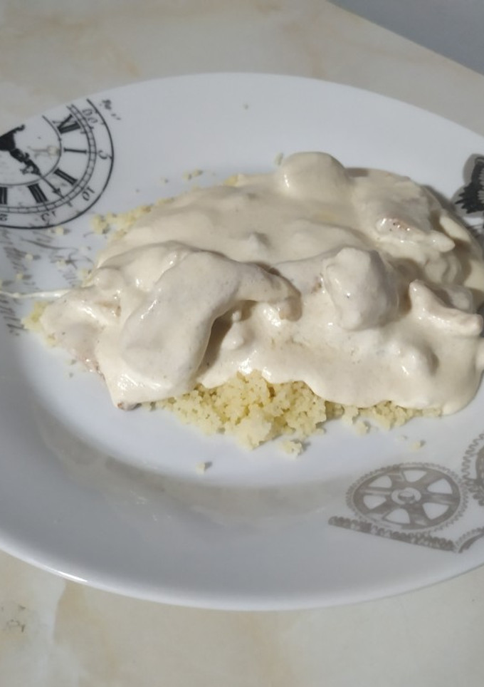 Una foto de Pollo con salsa de queso y cuscús