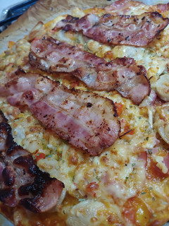 Una foto de Pizza casera Brackwurt con bacon y sofrito con curry