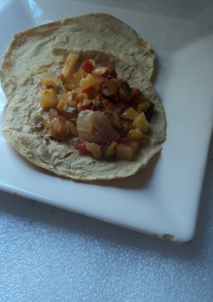 Una foto de Tacos de papa y carne molida con cebolla y poblano con mezcal