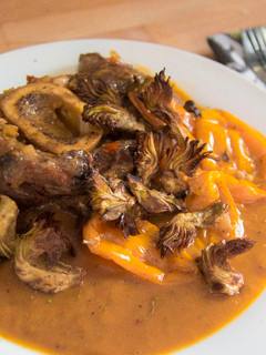 Una foto de Ossobuco guisado con chips de alcachofa