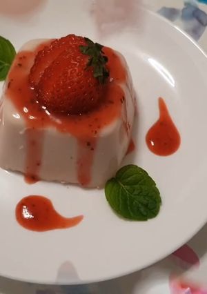 Una foto de Panna cotta de coco con coulis de fresa