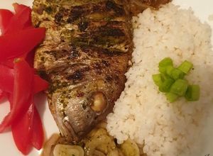 Una foto de Pescado a la varilla con cebolla marinada y arroz