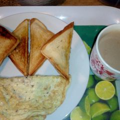 A picture of Toasted bread,fried Eggs and Hot Choco.