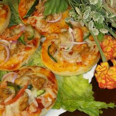 A picture of Mini pizza with speghetti.