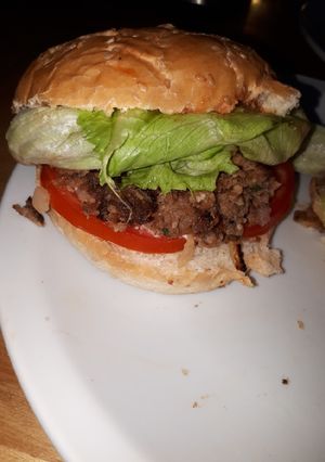Una foto de Hamburgesa casera de cebolla, morrón y barbacoa