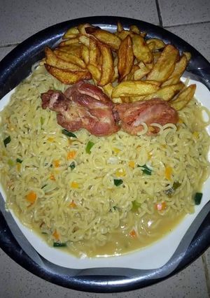 A picture of Indomine with carrots,green peas,chicken and Irish potatoes.