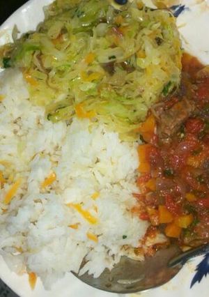 A picture of Carrot rice, steamed vegetables and beef stew.