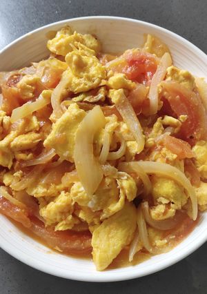 A picture of Scrambled Eggs with Tomatoes and Onions.
