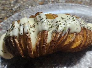 Una foto de Papas Hasselback con salsa de queso crema y tomillo