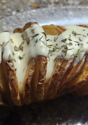Una foto de Papas Hasselback con salsa de queso crema y tomillo