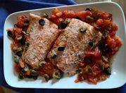 Una foto di salmone al forno con olive