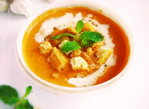 A picture of Creamy tomato soup with bread toast.