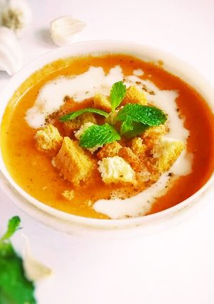 A picture of Creamy tomato soup with bread toast.