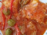 Una foto de bistec encebollado con tomate