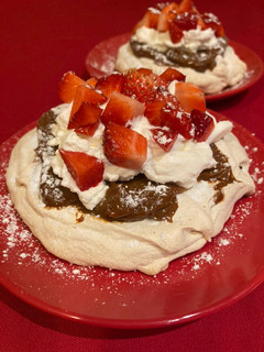 Una foto de Pavlova de almendras, dulce de leche, nata y fresas