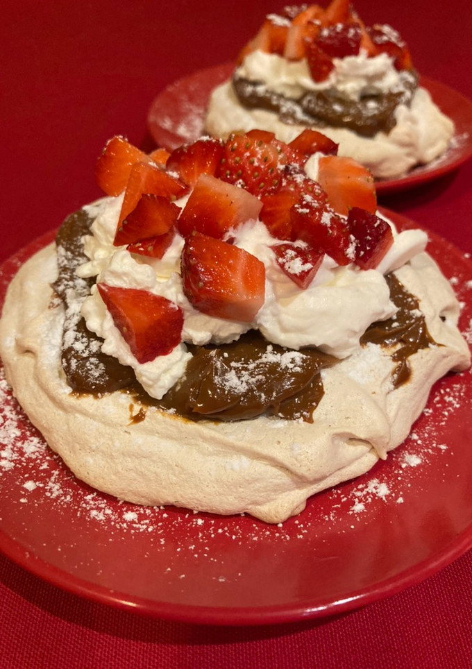 Una foto de Pavlova de almendras, dulce de leche, nata y fresas
