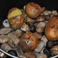 A picture of Baking Potatoes on Hot Stones.