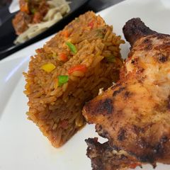 A picture of Jollof rice with grilled chicken.
