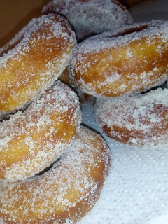 A picture of Sugar and milk coated doughnuts.