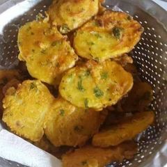 A picture of Fried potatoes with coriander and onions.