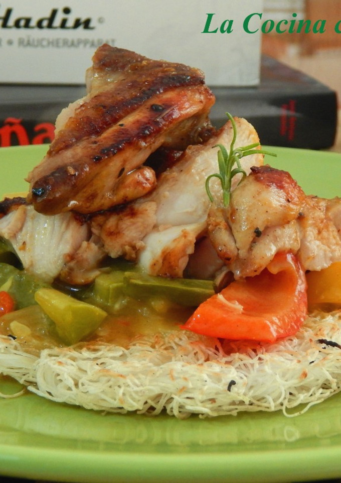 Una foto de Nidos crujientes de fideos de arroz con curry de verduras y pollo a la plancha
