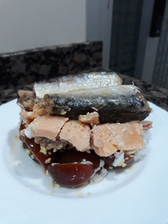 Una foto de Ensalada de cherrys, huevo rallado, salmón y sardinas